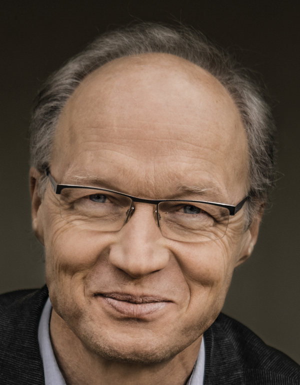 Eine Person mit Brille lächelt in die Kamera