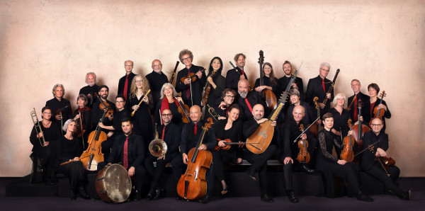 Eine Gruppe von Personen in schwarzer und roter Kleidung mit Instrumenten in den Händen.